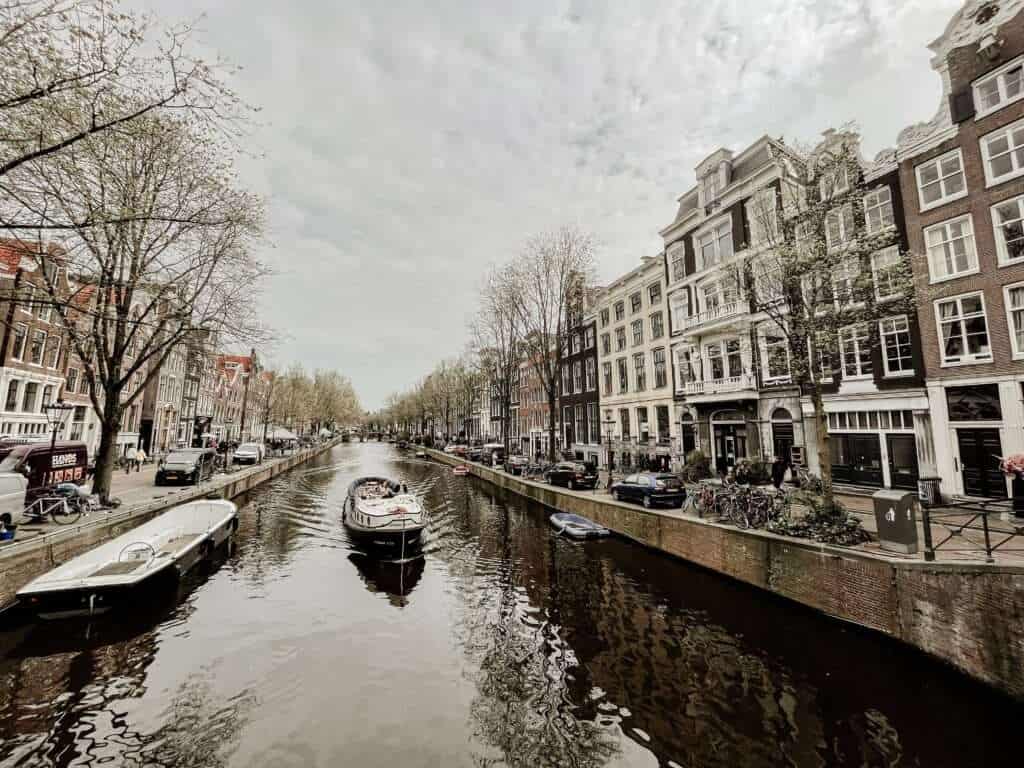 Amsterdam canal with boat riding on it